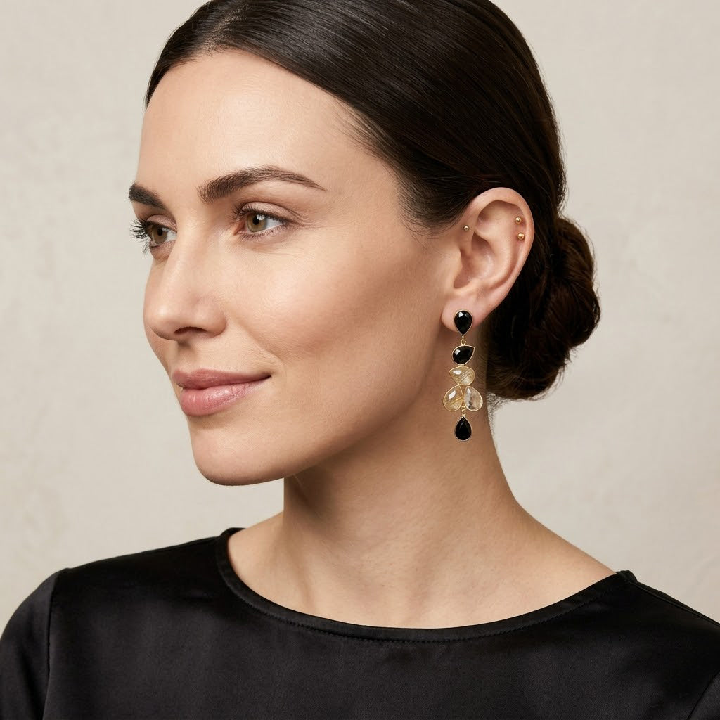 Gold earrings with rutilated quartz and black onyx stones in elegant dangle style
