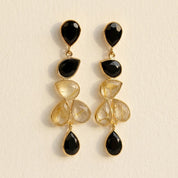 Close up of rutilated quartz earrings with black onyx gemstone accents
