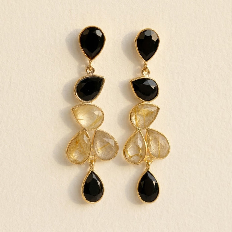 Close up of rutilated quartz earrings with black onyx gemstone accents
