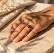 Dainty oval gemstone stacking rings in warm gold vermeil on woman's hand