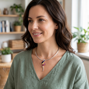 Woman wearing colorful boho spiral statement necklace with sage green blouse
