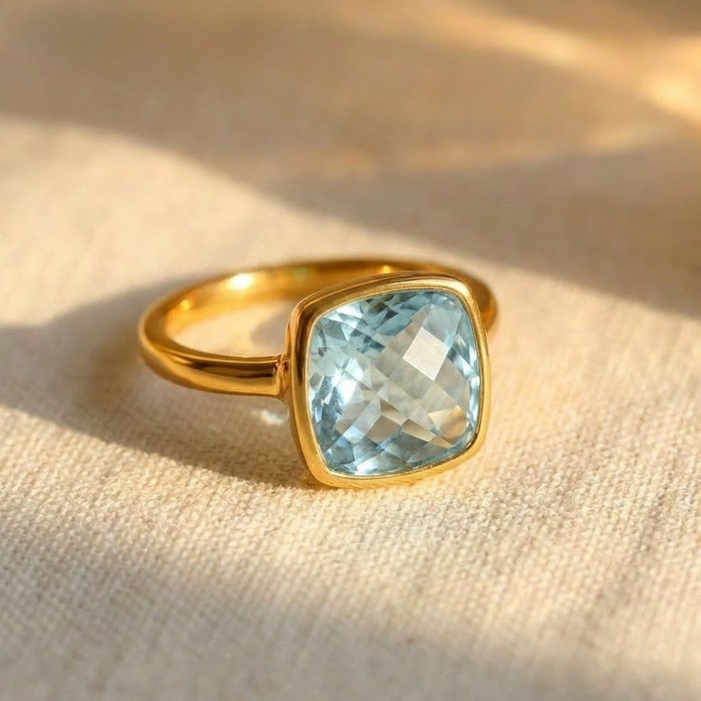 blue topaz gold plated cushion bezel square stacking ring on white background. december birthday, december gemstone. stacking ring, stackable, ring stack, square bezel set, bezel setting