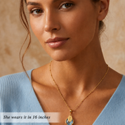Woman wearing a gold blue topaz name necklace at a 16-inch necklace length