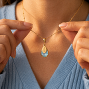 Woman holding a personalized December birthstone necklace with an engraved name charm