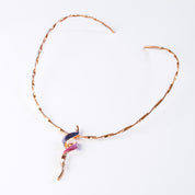 Necklace with a copper flat twisted wire neck ring and a tapered spiral pendant plated in rose gold and painted in purple and pink enamel against a white background