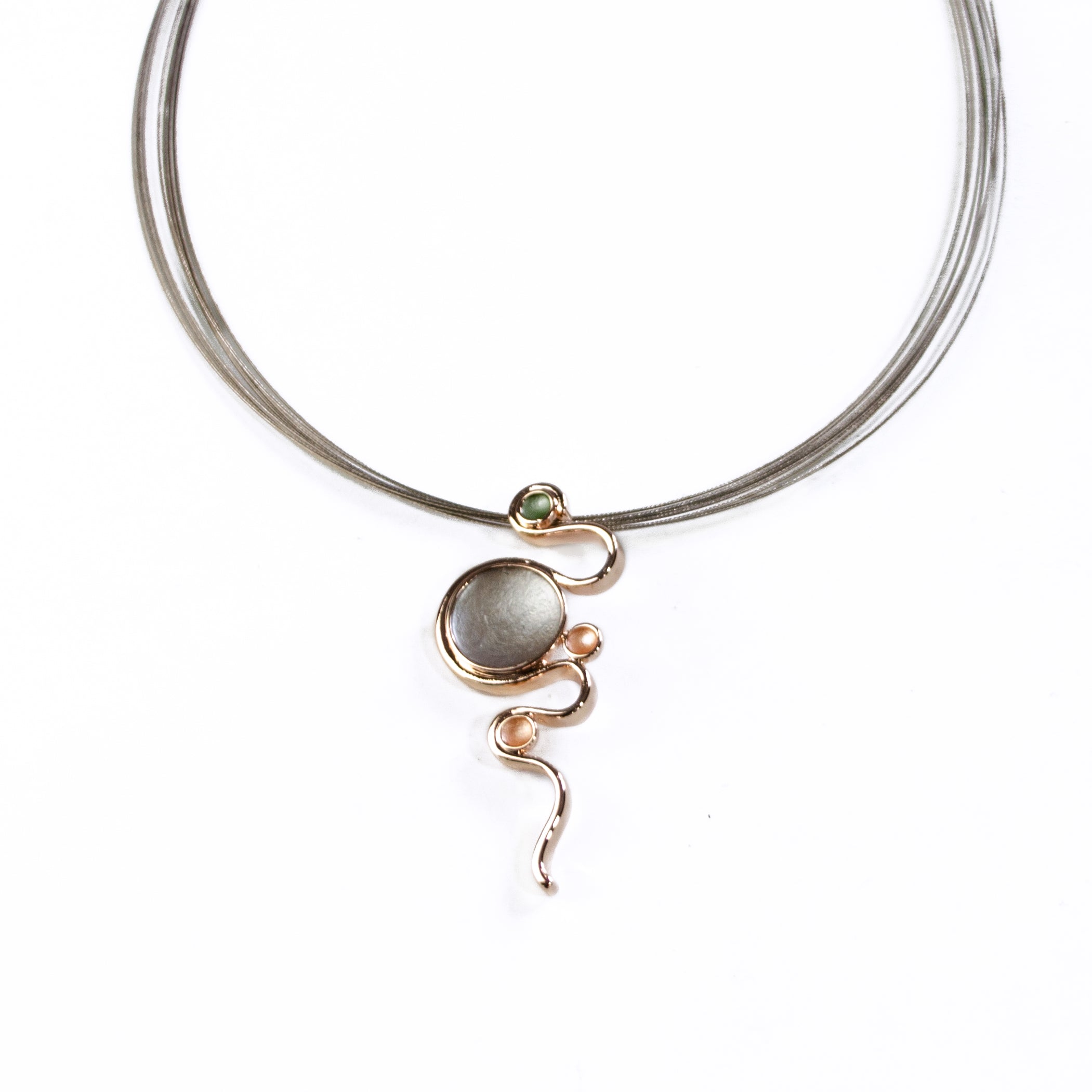 Adjustable Necklace with a brown steel wire chain and a rose gold plated pendant with a serpent snaking around three small circles and one large circle individually painted in green, gray, and gold enamel against a white background