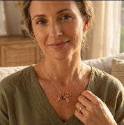 Mom holding her child while wearing a personalized children’s charm necklace with engraved names.
