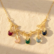 Gold family tree necklace with colorful teardrop birthstones and leaf charms
