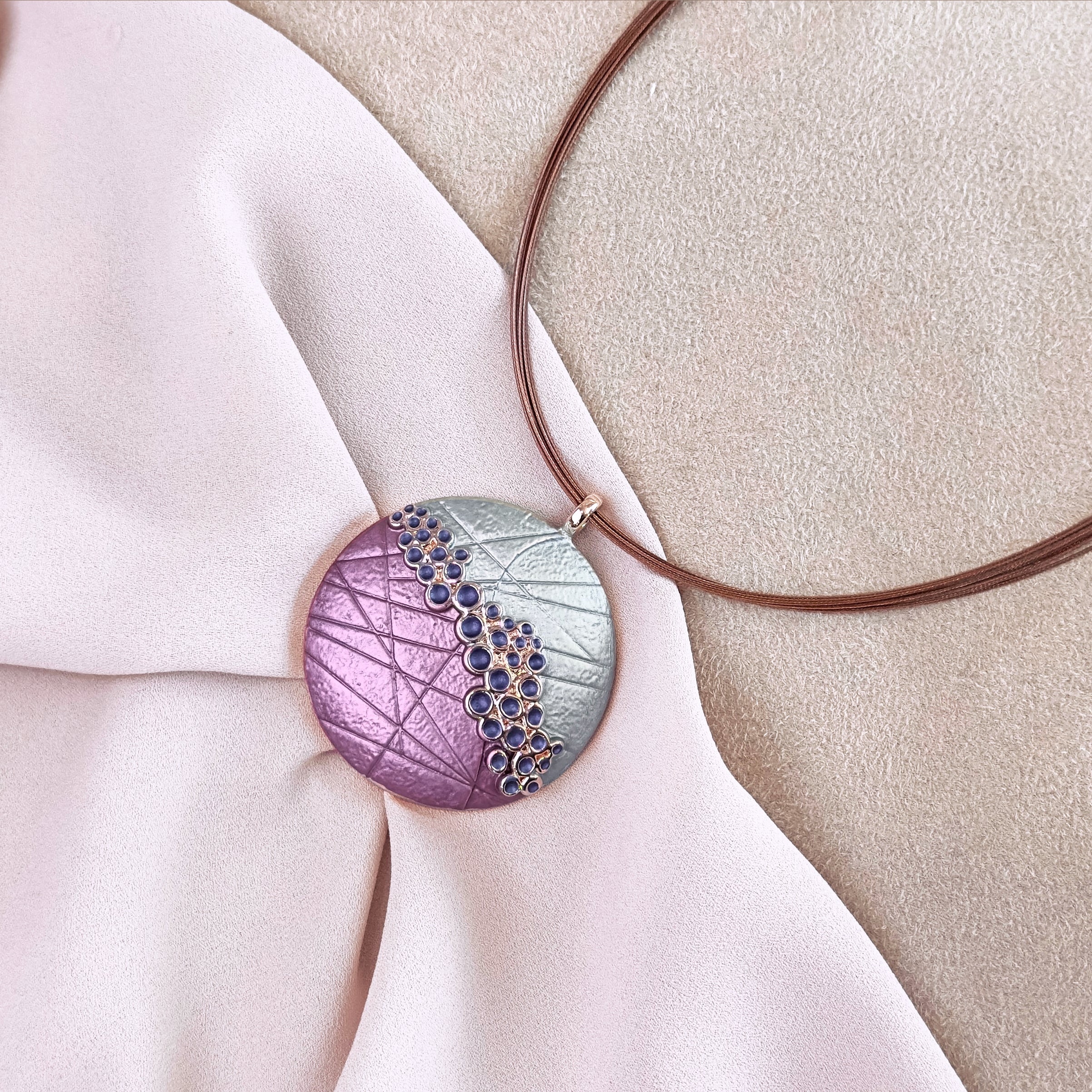 Rose gold Round Bubbles Pendant statement necklace and on beige background. steel cable chain and a zinc alloy pendant with a galvanic rose gold finish. bohemian jewelry, boho necklace