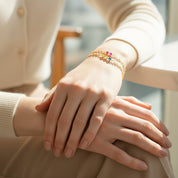 Woman wearing tiny cabochon birthstone bar bracelet on wrist, styled with cozy neutral outfit, showing how the delicate chain and small stones add a subtle pop of color, perfect everyday minimalist jewelry and sentimental gift for loved ones.