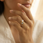 Woman wearing delicate oval cabochon birthstone rings in a minimalist gemstone ring stack