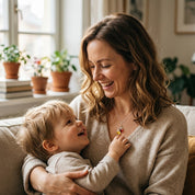 Mother wearing personalized birthstone initial necklace while holding child
