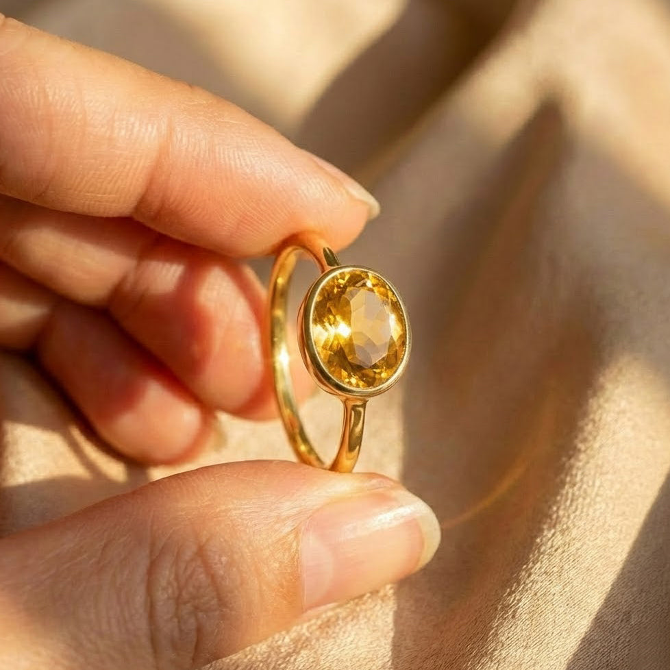 Lifestyle photo of a woman wearing an oval citrine ring stacked with other minimalist gemstone rings, showcasing a dainty gold band and bezel-set yellow citrine. Elegant birthstone stacking ring styled for everyday wear, personalized jewelry looks, and modern layering. Thoughtful gift for mom, wife, girlfriend, or best friend, ideal for November birthdays, anniversaries, Valentine’s Day, Mother’s Day, and meaningful family jewelry collections.
