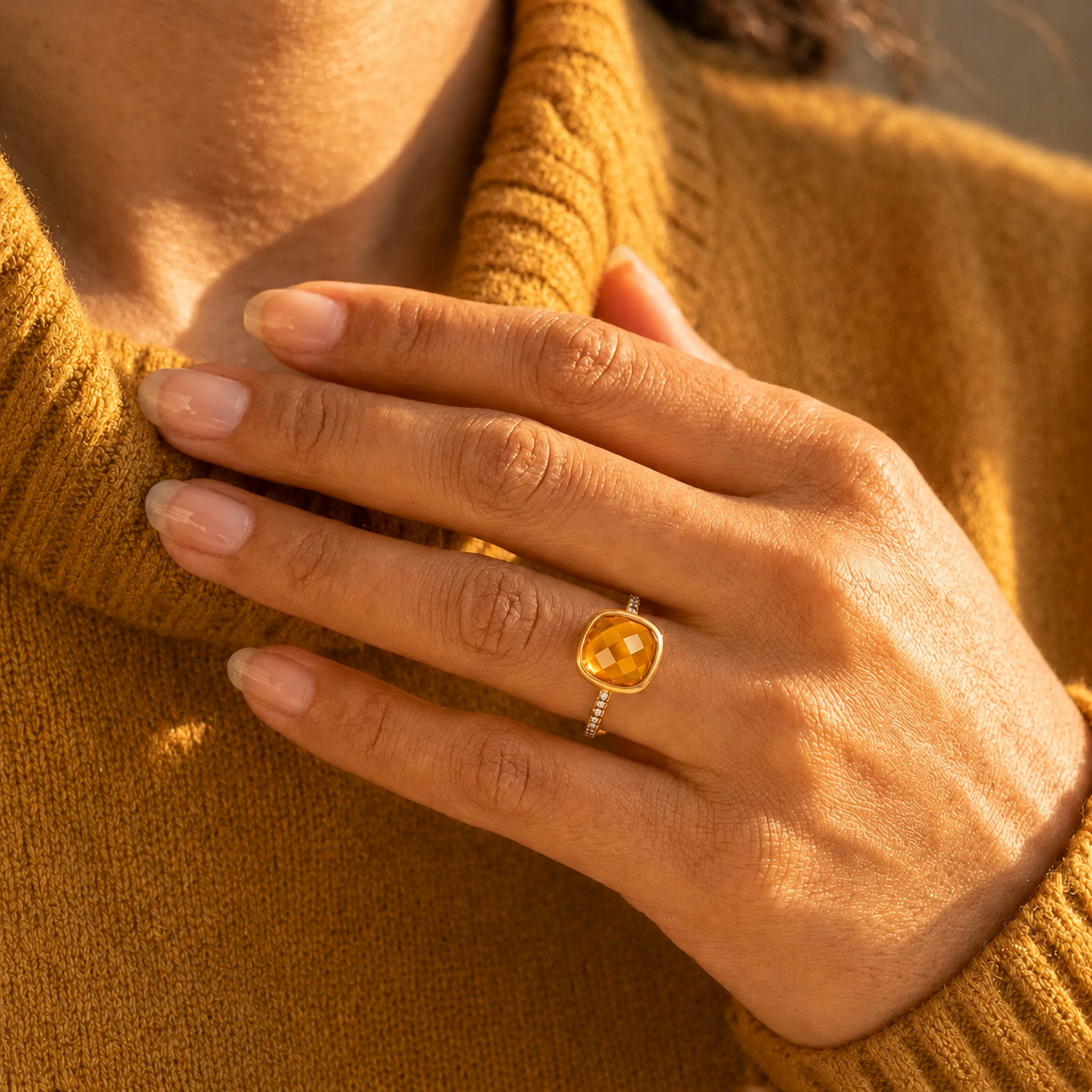 Woman wearing a gold vermeil citrine pavé cushion ring in natural sunlight