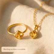 Diamond-shaped citrine ring displayed with its matching gemstone necklace