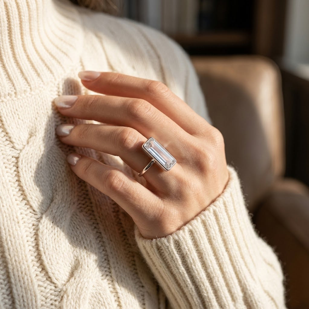 Woman wearing clear quartz ring, dainty rectangle crystal stacking ring in gold
