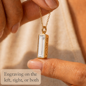 Gold clear quartz April birthstone necklace with information about the faceted 16 by 6 mm gemstone.