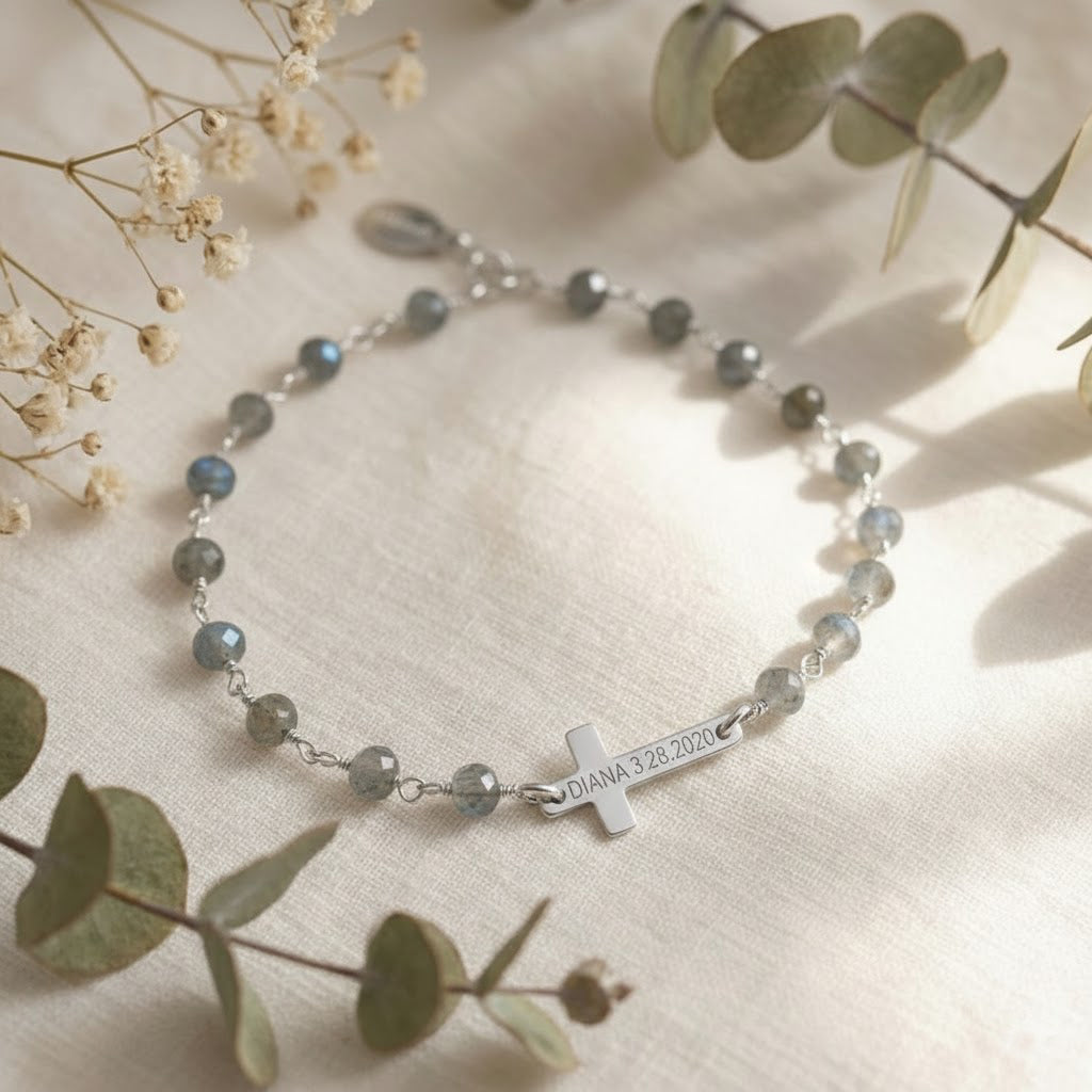 Close-up macro of engraved cross bracelet showing name plate, high polish finish, and premium materials; personalized women’s jewelry gift idea. Sterling silver engraved cross on natural labradorite wire wrapped chain