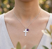 Close-up of woman wearing engraved cross and birthstone necklace, delicate personalized religious necklace