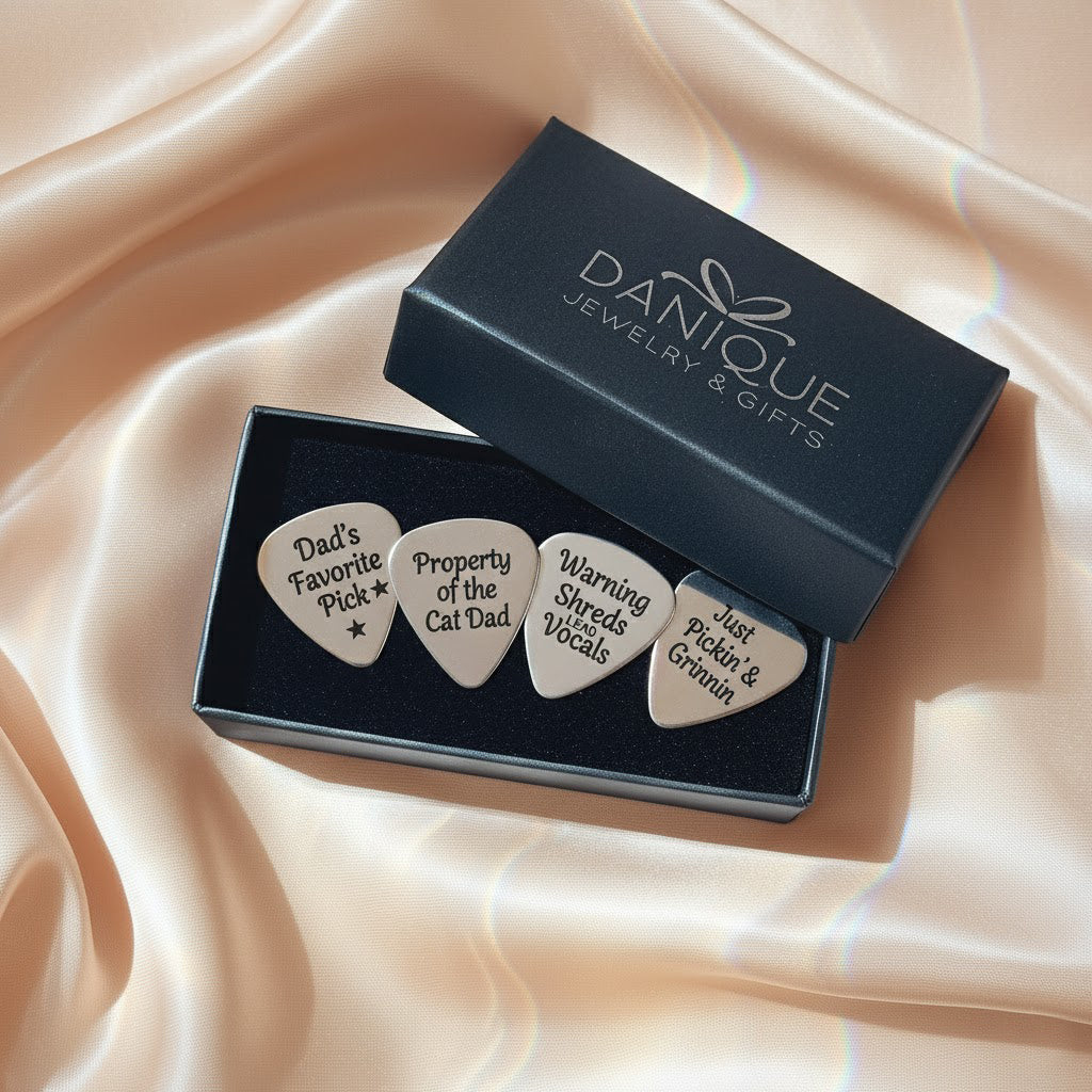 Premium Danique Jewelry gift box opened to reveal a set of four custom engraved guitar picks nestled inside, each with a different romantic or inspirational phrase, ready for gifting. Personalized stainless steel plectrum set for guitar players and music lovers, perfect keepsake gift for anniversaries, Valentine’s Day, weddings, Father’s Day, Christmas or birthdays, meaningful way to say “I pick you.”