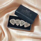 Premium Danique Jewelry gift box opened to reveal a set of four custom engraved guitar picks nestled inside, each with a different romantic or inspirational phrase, ready for gifting. Personalized stainless steel plectrum set for guitar players and music lovers, perfect keepsake gift for anniversaries, Valentine’s Day, weddings, Father’s Day, Christmas or birthdays, meaningful way to say “I pick you.”