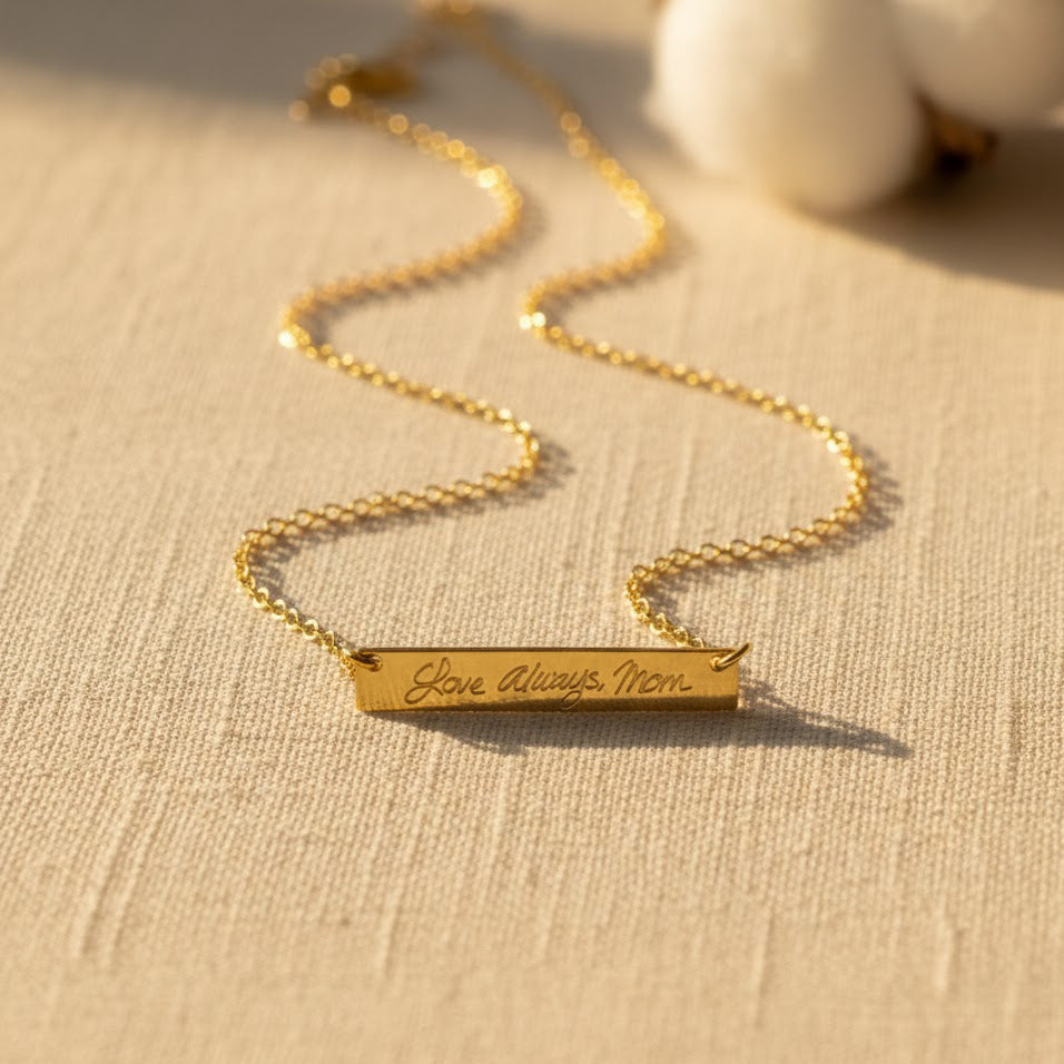 Minimalist engraved gold bar necklace worn on neckline, personalized custom message necklace, elegant dainty jewelry for everyday wear.