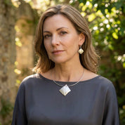 Woman wearing Soft Pearl sculpted leaf necklace and matching earrings outdoors

