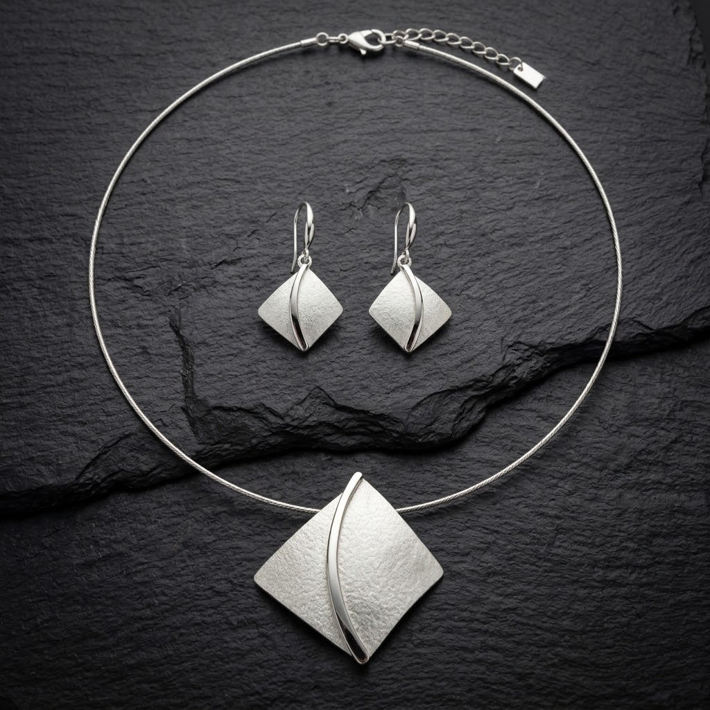 Soft Pearl sculpted leaf necklace and matching drop earrings displayed on black background
