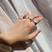 A hand wearing an assortment of rings including dog nose rings. Custom dog nose ring, engraved pet jewelry, sterling silver dog ring, gold vermeil dog ring, rose gold pet keepsake, personalized pet memorial, dog lover gift, pet portrait jewelry, unique pet ring, custom engraving, paw print jewelry, dog owner accessory