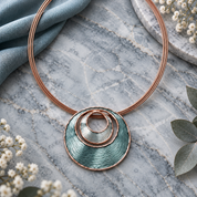 Full Sea Ice Layered Halo pendant necklace displayed on gray stone