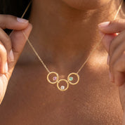 Personalized birthstone circle necklace for Mom with three open gold circles and colorful children's gemstones.
