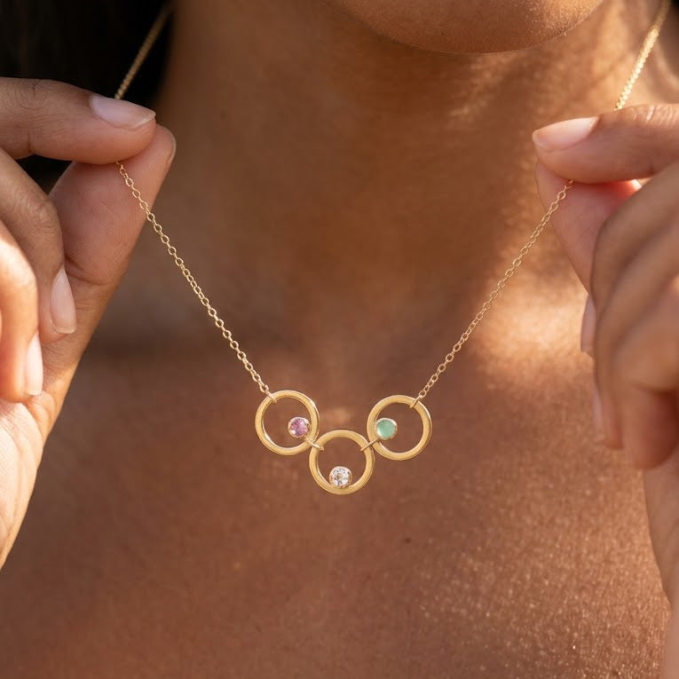 Personalized birthstone circle necklace for Mom with three open gold circles and colorful children's gemstones.
