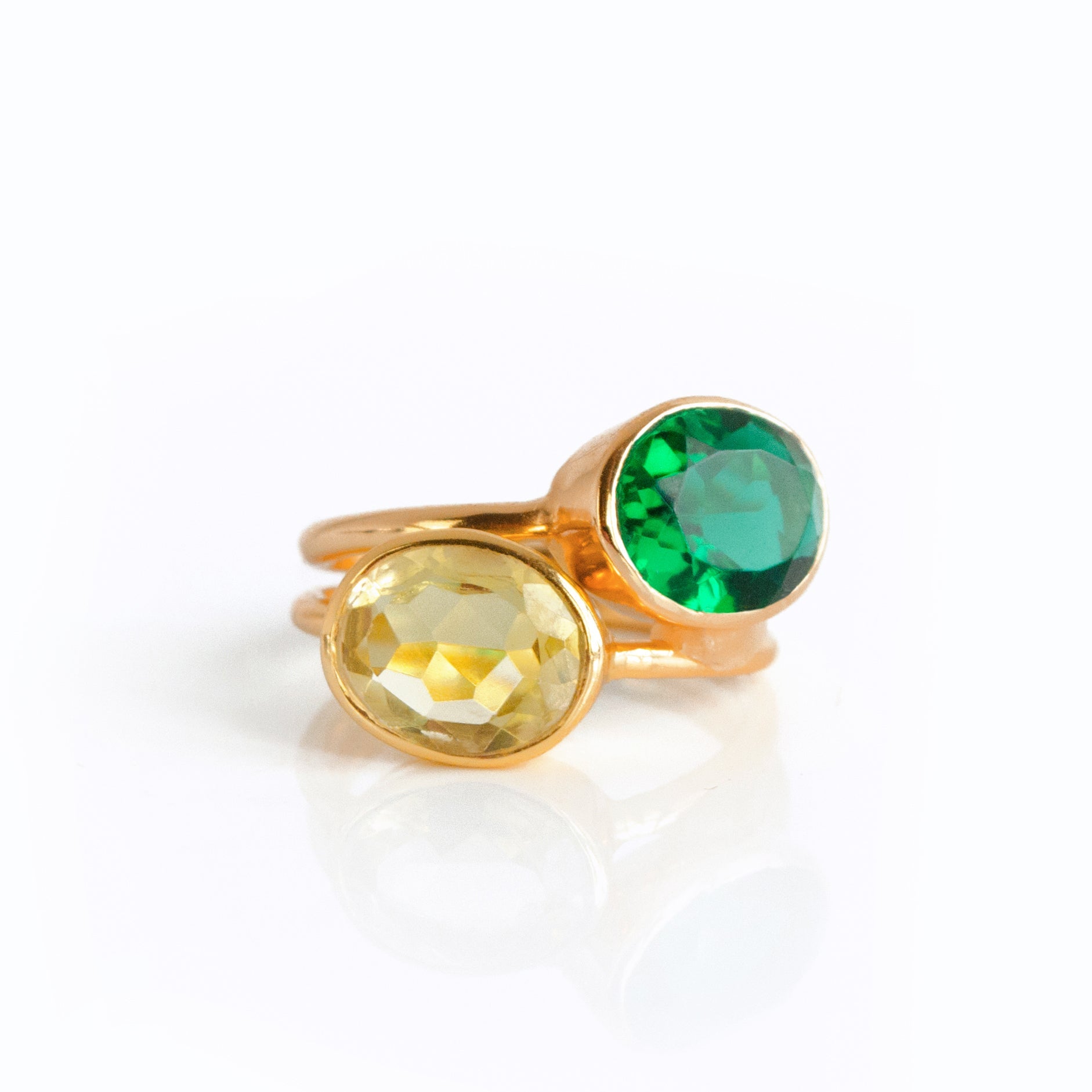 Two oval gemstone rings in vermeil rose gold and yellow gold rest against a white background. Emerald quartz sits on top, Citrine quartz is on the bottom. Stacking rings, birthstone stacking rings, May birthstone ring, November birthstone ring, gift for mom with many children