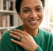 Model wearing emerald quartz cushion ring near her shoulder with green sweater, showing ring scale and everyday styling.