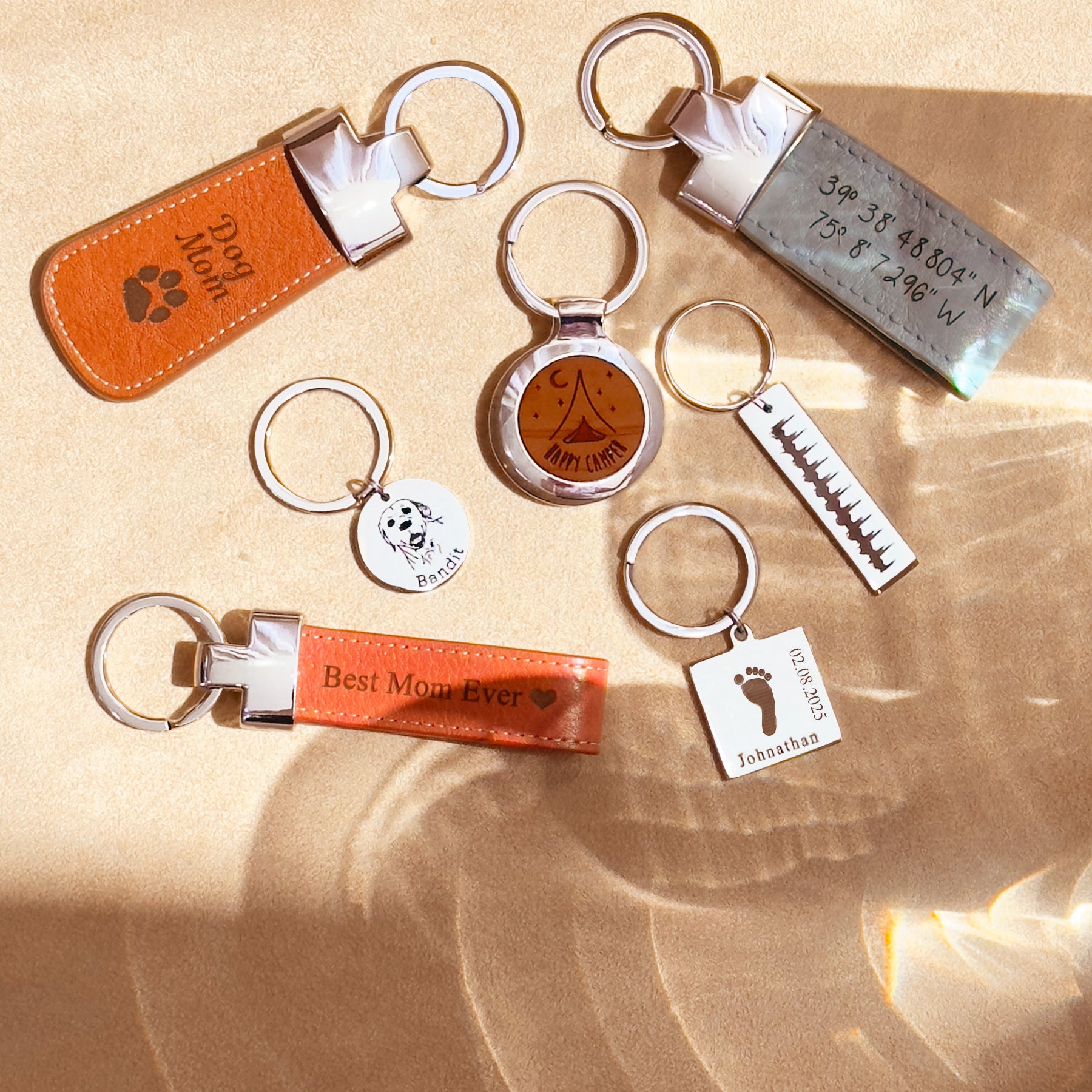 Mixed metal bar keychains displayed with leather tags and charms to show stacking options; personalize with GPS, names, dates or a secret message on back; versatile engraved location keychain for him or her; secondary phrases: anniversary gift for him, wedding gift for him, keychain for boyfriend; polished stainless steel in silver, gold or black.