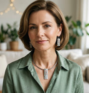 Woman wearing matching pink and blue floral pendant necklace