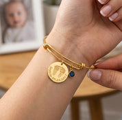 Mom wearing personalized baby footprint bangle bracelet with birthstone charm, a custom push present and new baby jewelry gift.
