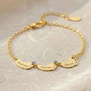 Personalized footprint bracelet with custom engraved kids’ names and tiny birthstones, shown in 18K gold-filled finish; delicate family bracelet with multiple charms for mom or grandma, customized with up to six children’s names and birthstones.