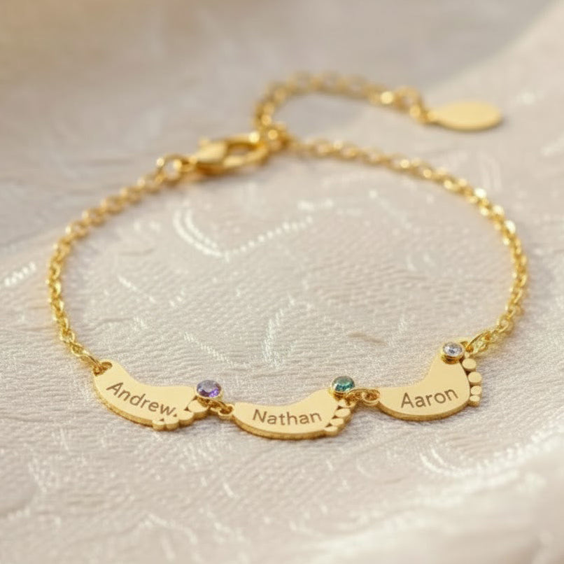 Personalized footprint bracelet with custom engraved kids’ names and tiny birthstones, shown in 18K gold-filled finish; delicate family bracelet with multiple charms for mom or grandma, customized with up to six children’s names and birthstones.