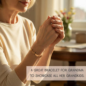 A grandmother fastening a custom engraved footprint bracelet with name charms and birthstones, meaningful mom jewelry that celebrates children or grandchildren, perfect for gifting.