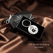 Gift-ready packaging for a personalized baby footprint keychain, presented in a Danique Jewelry box with satin fabric. This engraved baby footprint keychain is made from durable stainless steel and customized from an actual footprint photo, making it a perfect keepsake gift for new moms, Mother’s Day, baby showers, or meaningful memorial jewelry.