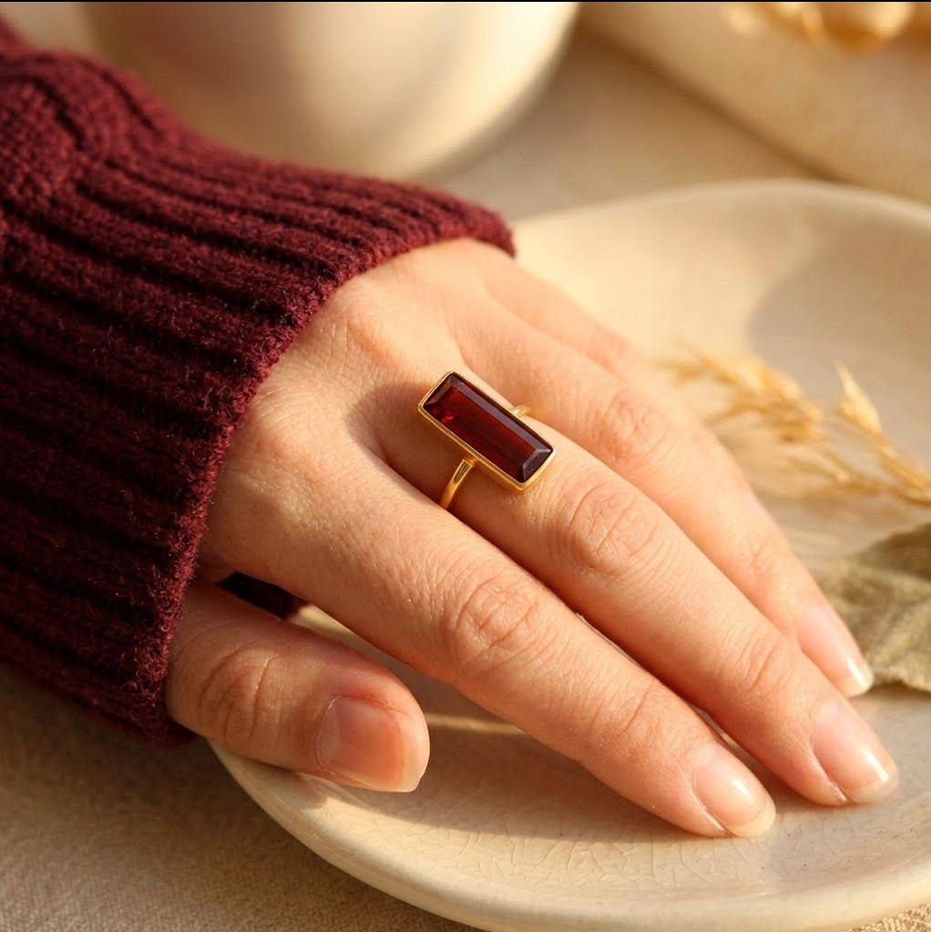 Woman wearing vertical Garnet Quartz January birthstone ring in gold
