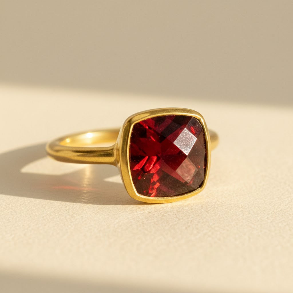 Garnet cushion cut gold ring on ivory background – January birthstone gemstone ring in 14k gold vermeil