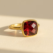 Garnet cushion cut gold ring on ivory background – January birthstone gemstone ring in 14k gold vermeil