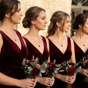 Bridesmaids wearing matching garnet necklaces, red gemstone bridal party jewelry and January birthstone gifts