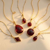 Garnet necklace collection in gold with teardrop, round, oval, and baguette pendants, January birthstone necklaces for women