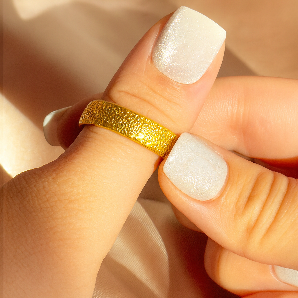 Close-up of a woman’s hand wearing a gold dog nose engraved ring, showing the textured nose print pattern across the wide band; personalized pet memorial jewelry crafted in gold vermeil, perfect as a meaningful remembrance gift for dog owners and pet lovers.
