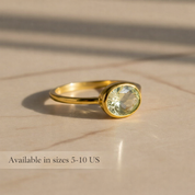 Small oval green amethyst bezel ring photographed from the side, highlighting the smooth setting and delicate band. Minimalist prasiolite gemstone ring designed for stacking or wearing alone. Handmade February birthstone jewelry available in sterling silver and gold vermeil finishes.