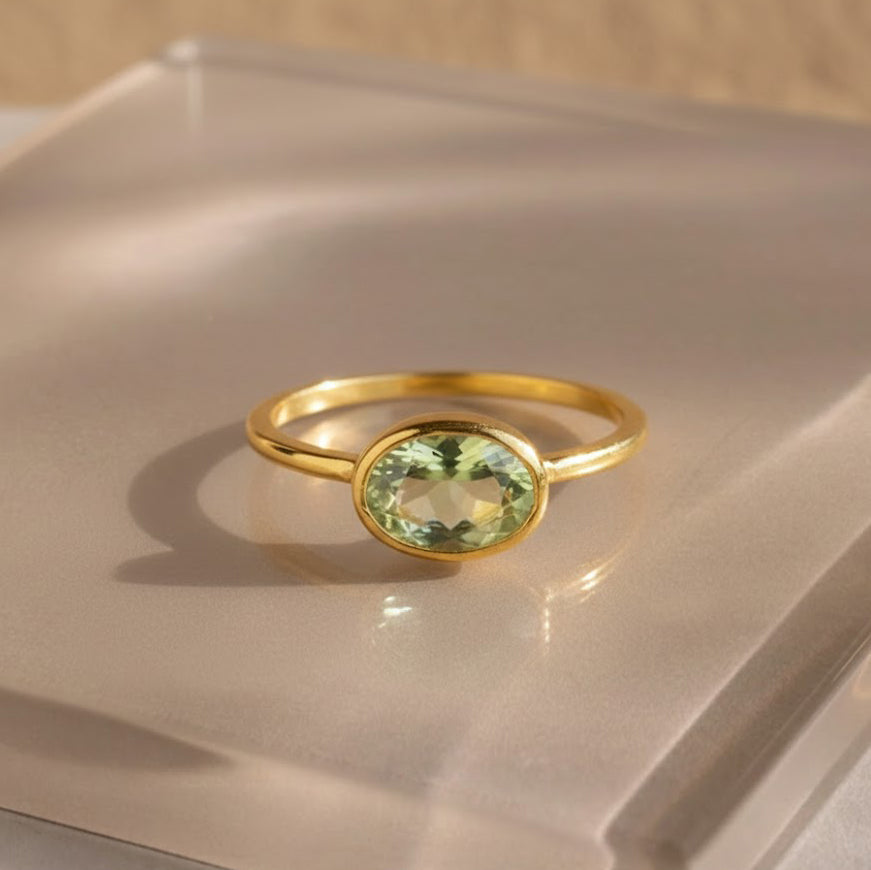 a gold green amethyst ring shown on beige background. green gemstone, green birthstone, february birthstone, february gemstone, stack set, stacking rings, gemstone ring, birthstone ring, mother's day gift for her, gift for mom, gift for fiance, gift for girlfriend, wedding jewelry, bridesmaid jewelry, anniversary jewelry, anniversary gift, birthday gift, christmas gift, valentine's day gift, valentine's day rings, dainty ring, cocktail ring, statement ring, bezel set