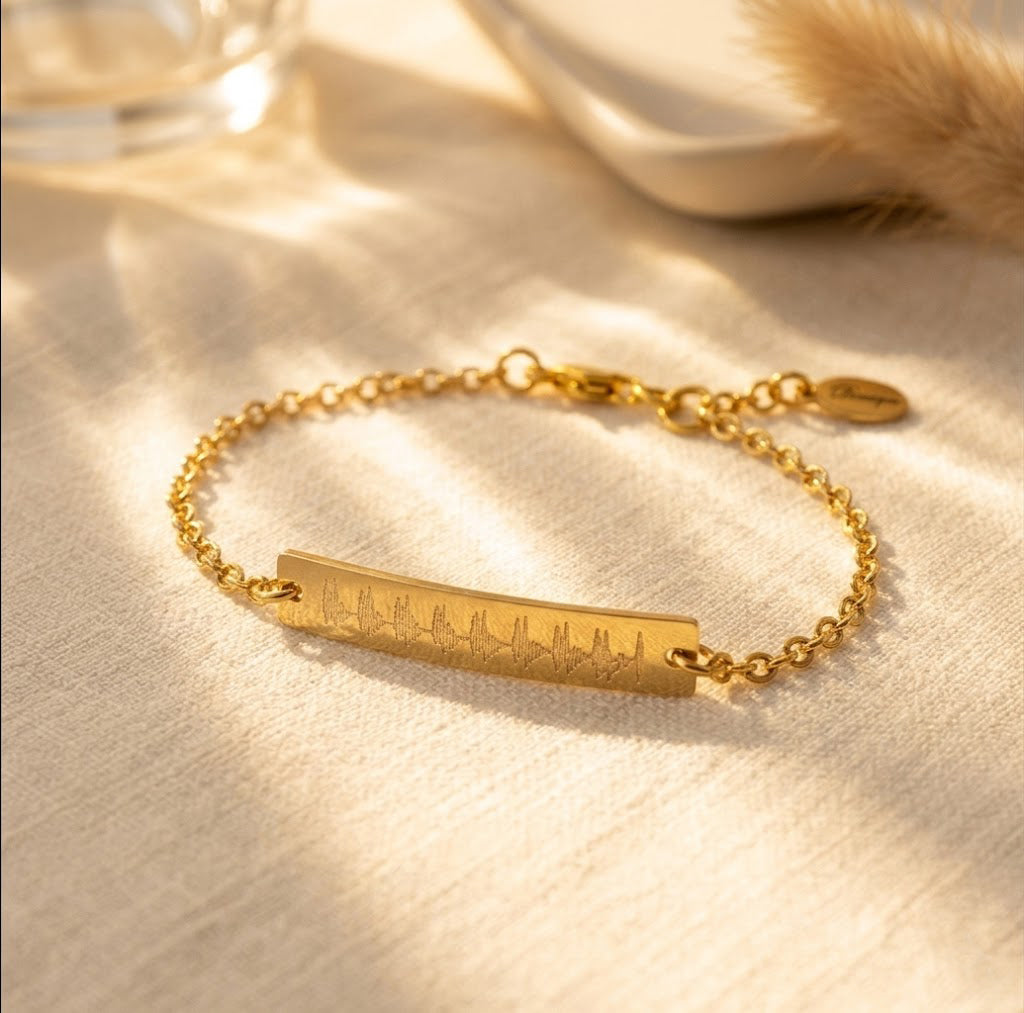 A gold-filled sonogram bracelet is laying flat against a white background. This heart beat jewelry can be engraved with a custom ekg, ultrasound or sonogram to capture your babys first signs of life! Ultrasound jewelry, sonogram jewelry, ekg jewelry